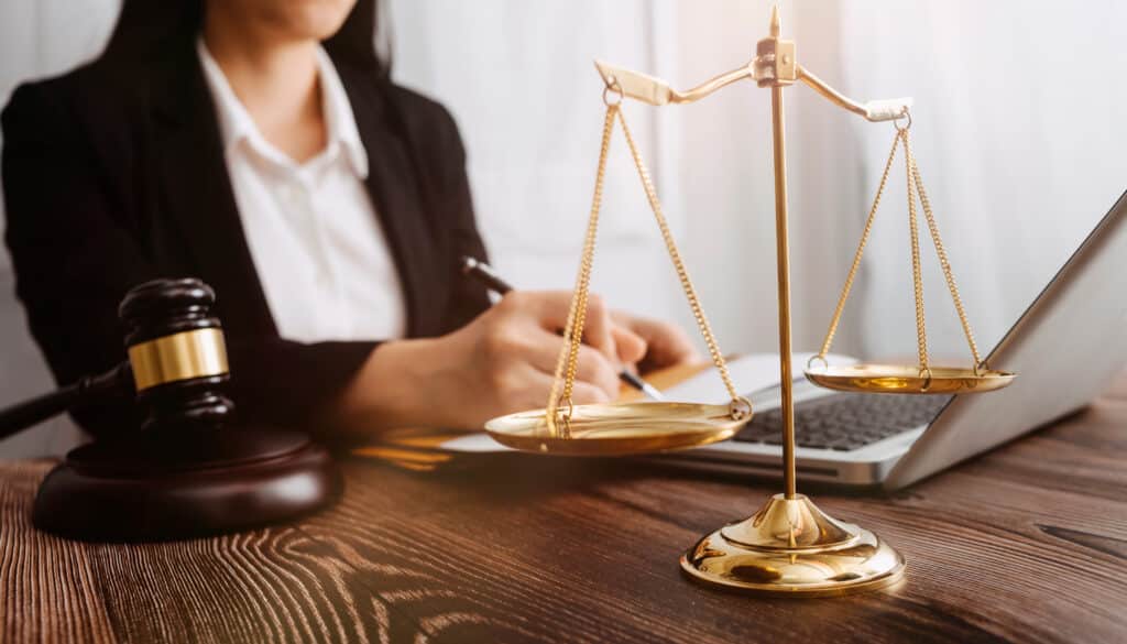 Travail d'avocat avec balance de justice et marteau de juge sur bureau.